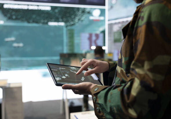 Army recruit examines satellite reconnaissance system on a world map