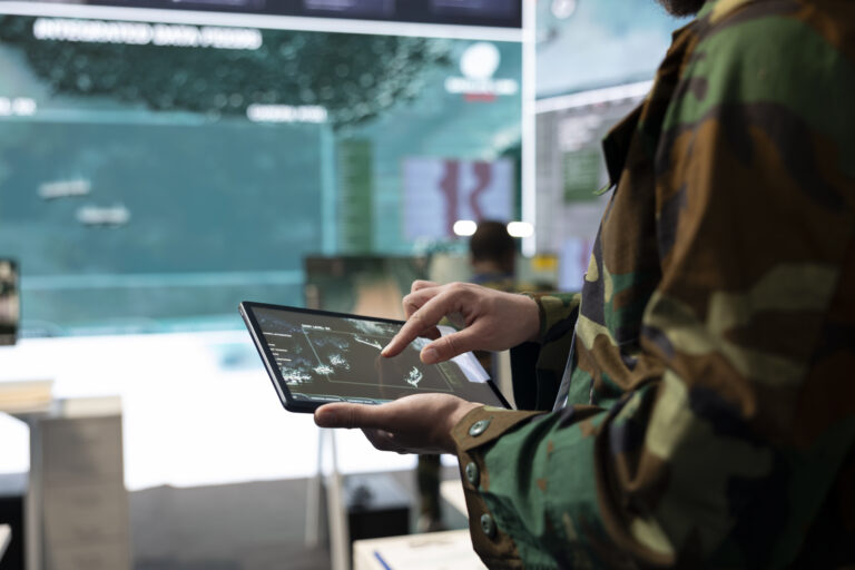 Army recruit examines satellite reconnaissance system on a world map