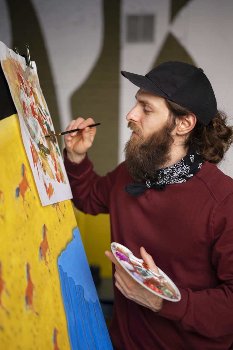 pintor-masculino-en-el-estudio-usando-acuarela-en-su-arte